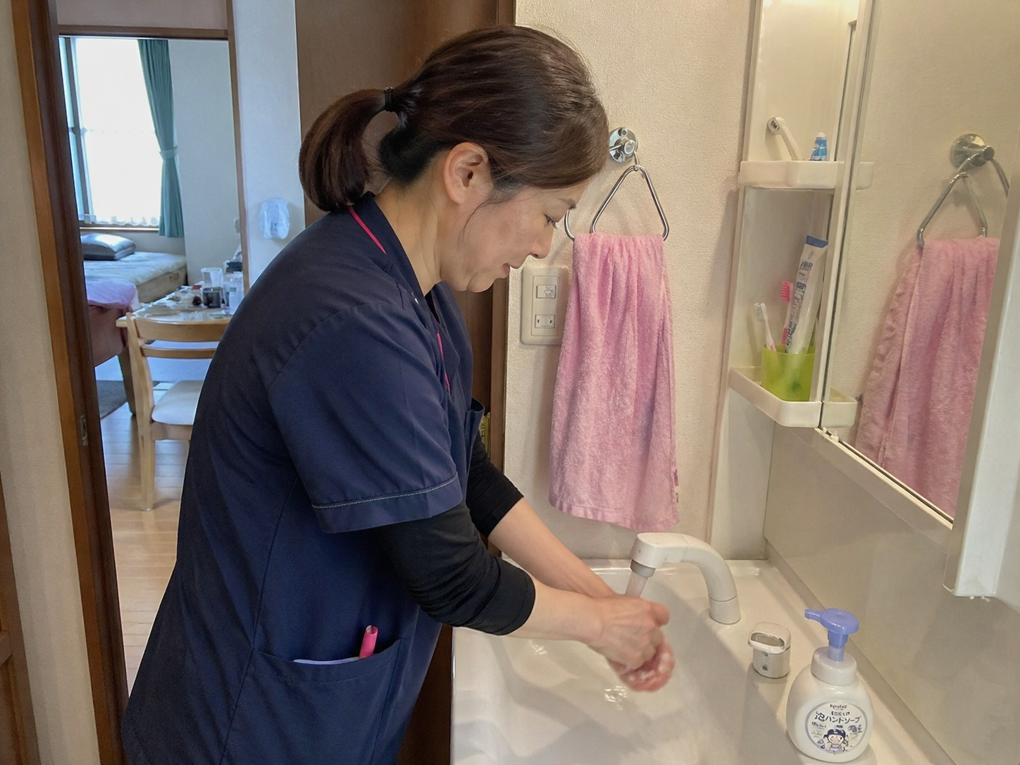 訪問先で手を洗う看護師
